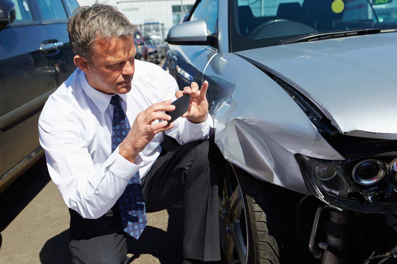 Vehicle damage inspection report shown beside a car